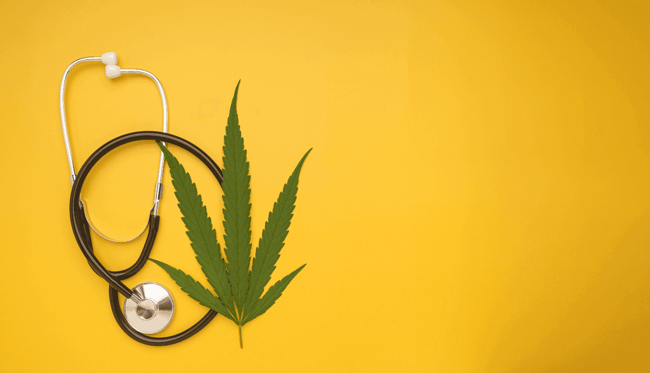 Stethoskop und Cannabisblatt auf gelbem Hintergrund